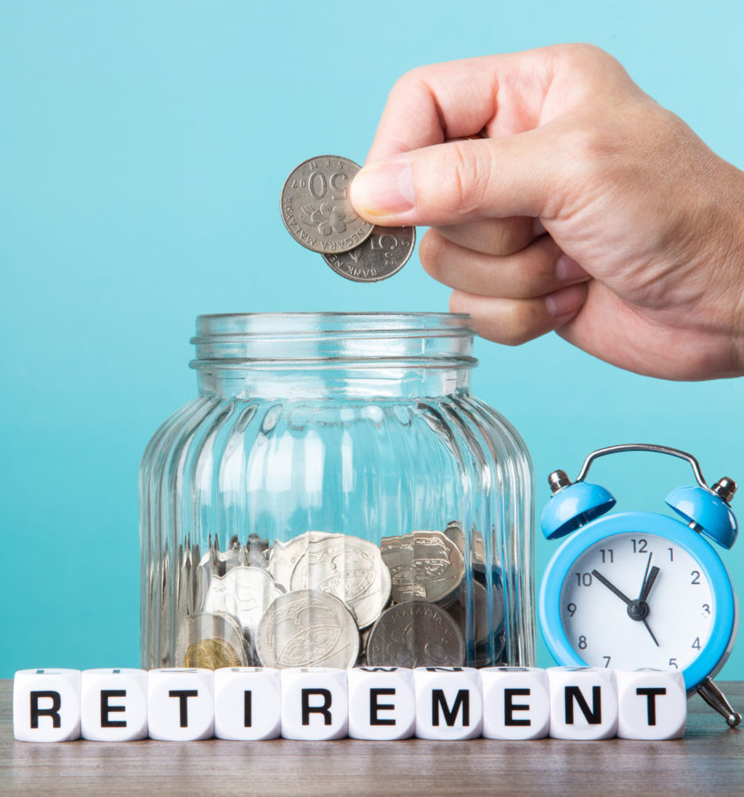 Hand putting quarters into a jar with the words "retirement" for Retirement Planning.